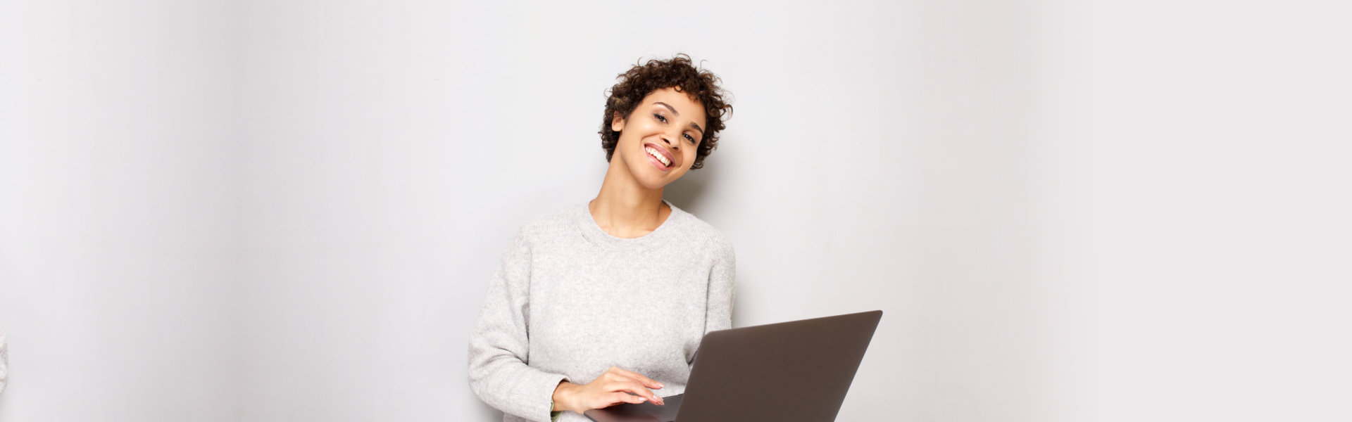 smiling woman holding her laptop